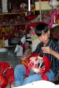 Мальчик мастерит китайские фонарики. Хойан
